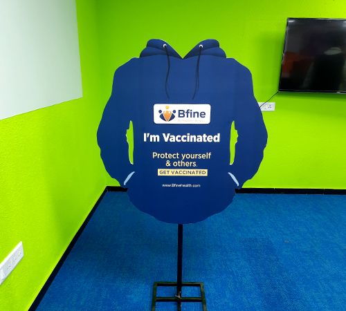 man wearing a black jacket, white shirt, blue jeans, and brown boots, playing a white electric guitar while sitting on an amp