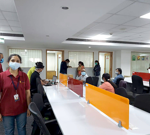 man wearing a black jacket, white shirt, blue jeans, and brown boots, playing a white electric guitar while sitting on an amp