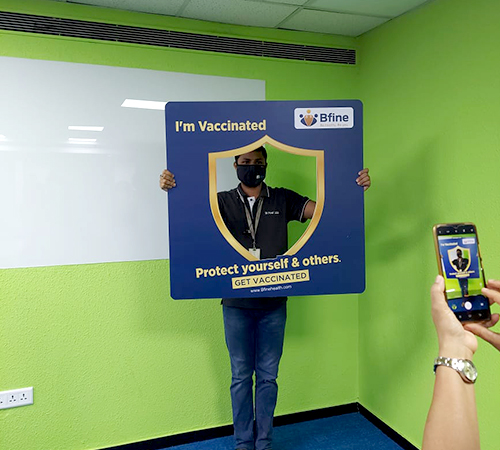 man wearing a black jacket, white shirt, blue jeans, and brown boots, playing a white electric guitar while sitting on an amp