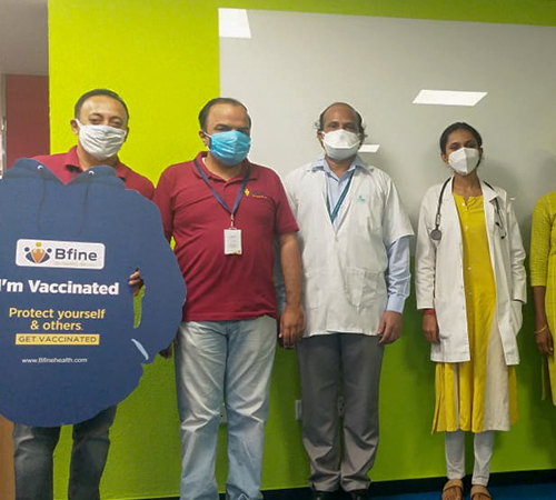 back view of woman wearing a backpack and beanie waiting to cross the road on a busy street at night in New York City, USA